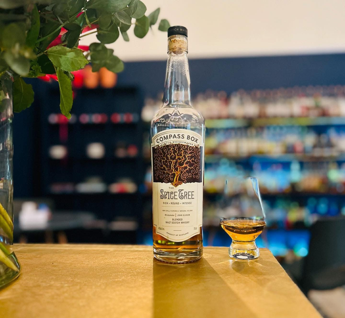 The Spice Tree Whisky bottle and a glass in the bar background 