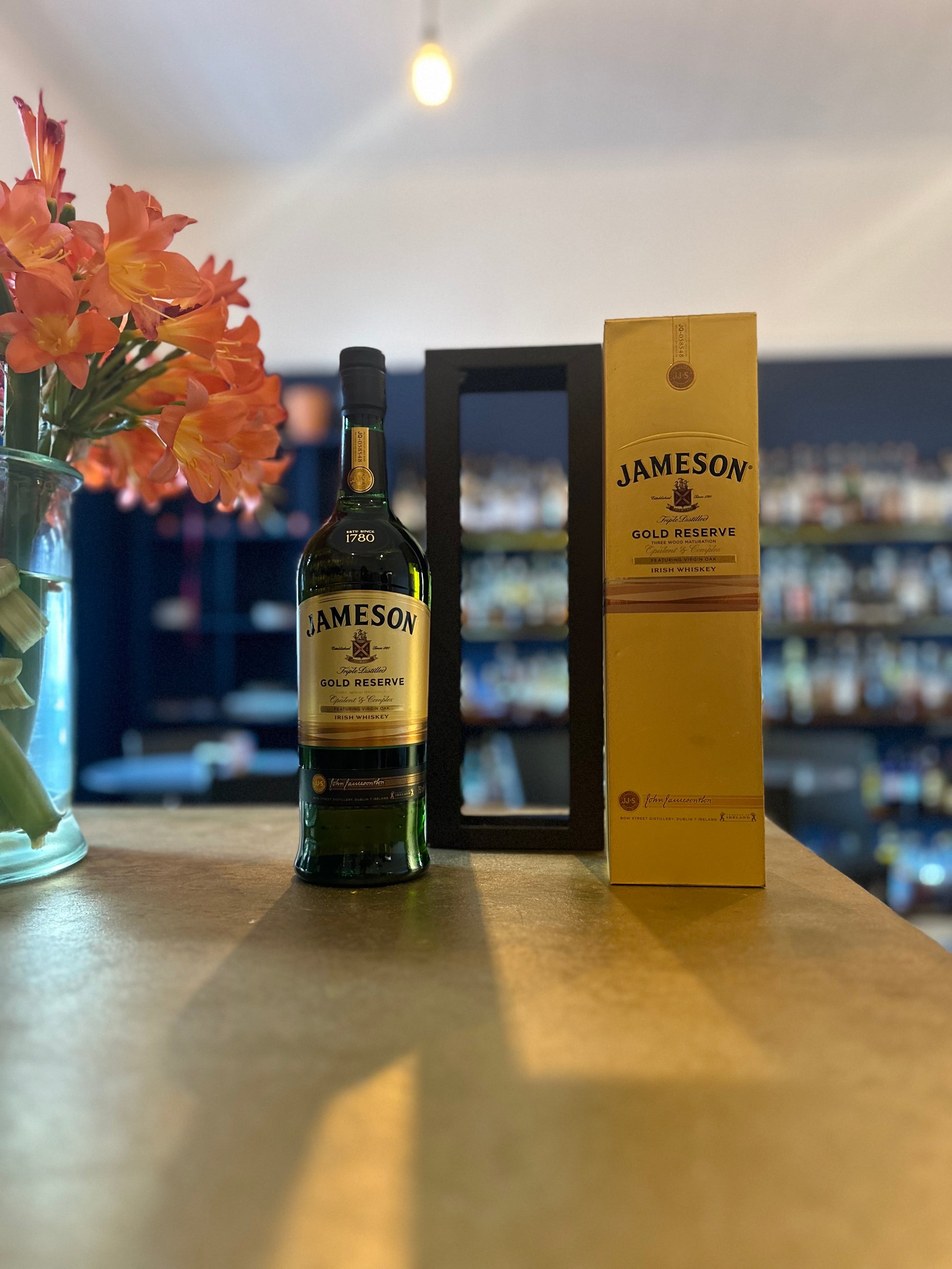 Jameson Gold Reserve Bottle and a Case on a Bar background