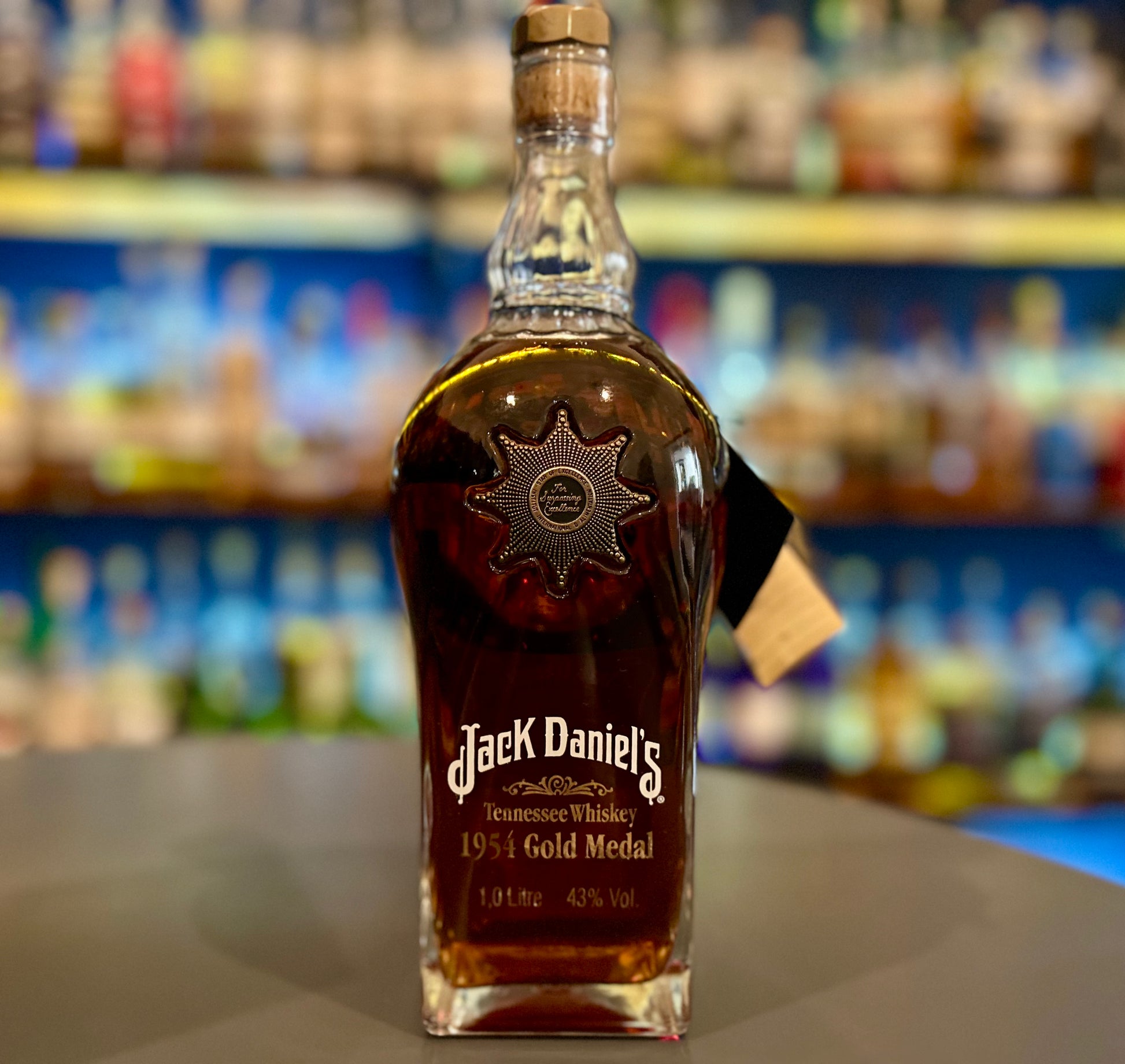 Jack Daniel's 1954 gold medal bottle on a bar counter with a blurred bar background
